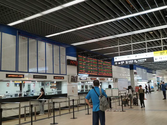 Photographed at Taipei Main Station, where red-and-green departure boards hang above the ticket windows as travelers check the next leg of their journeys.