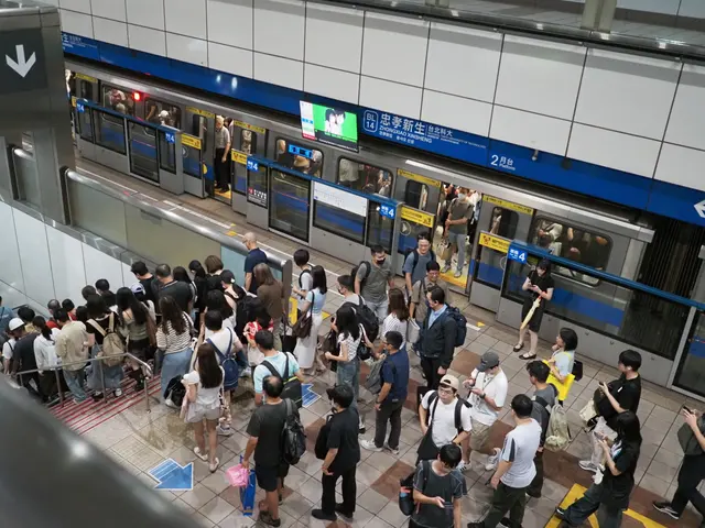 Photographed at Zhongxiao Xinsheng Station on the Taipei Metro, where passengers stream toward the escalators after a train opens during the evening rush.